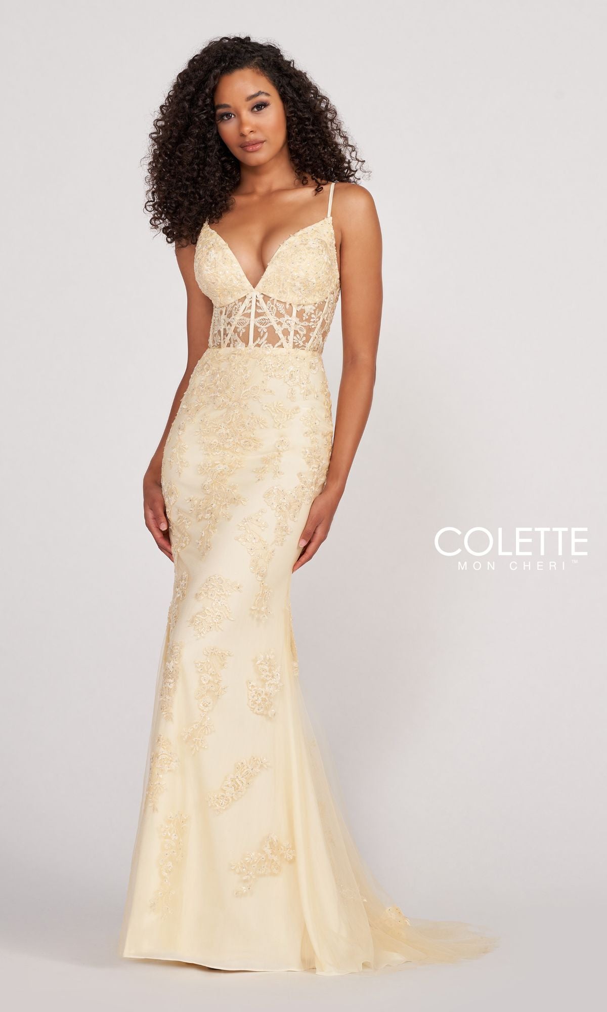 A woman poses against a plain background in the Colette Beaded-Lace Long Prom Dress with Corset, featuring light yellow beaded-lace detailing, a sheer bodice, thin straps, and a flattering mermaid silhouette.